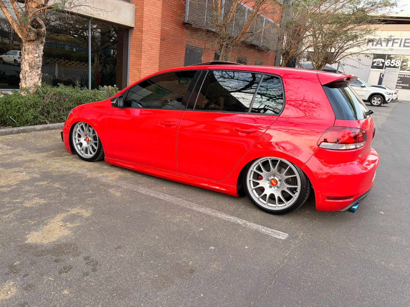 Red Golf GTI side profile on silver multi-spoke wheels